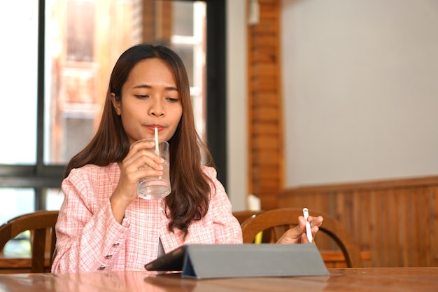 Asian woman braces watch computer drink water