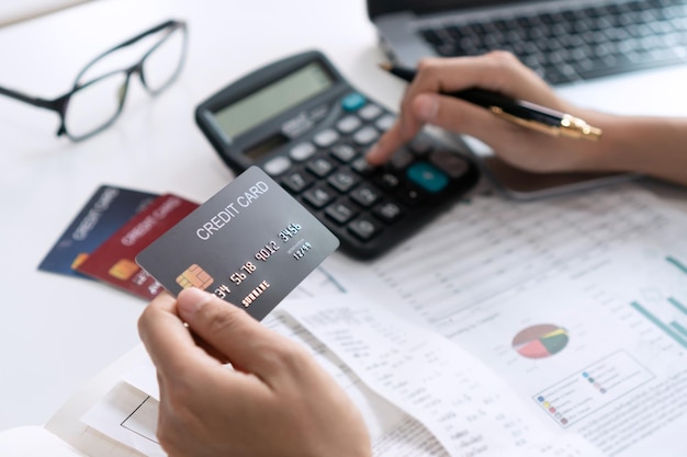 Asian woman checking bills taxes bank account balance and calculating credit card expenses Family financial planning concept Close up