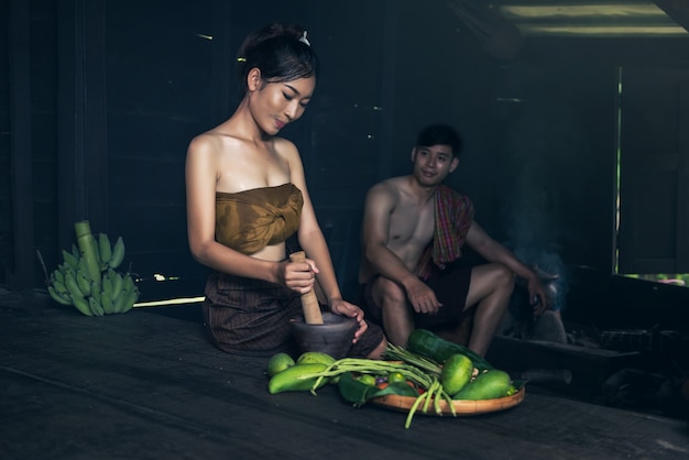 Asian woman cooking papaya salad at home countryside of Thailand