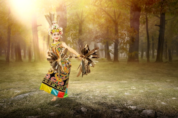 Asian woman dancing East Kalimantan traditional dance (Giring-Giring dance) on the field