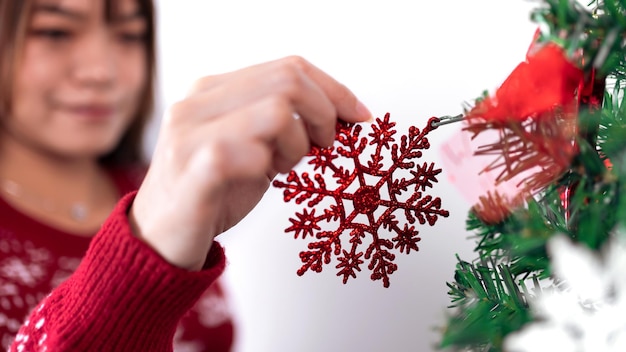 Asian woman decorating christmas tree with snowflake Girl Xmas ornaments