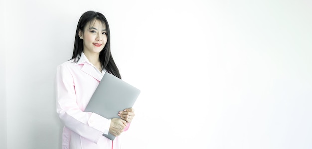 Asian woman doctor hand holding computer laptop gadget with copy space on white background Asian woman doctor in pink coat with computer laptop Medical and healthcare