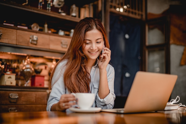 Asian woman drinking coffee latte in cafe vintage color tone