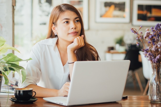 Asian woman drinking coffee in vintasg color tone