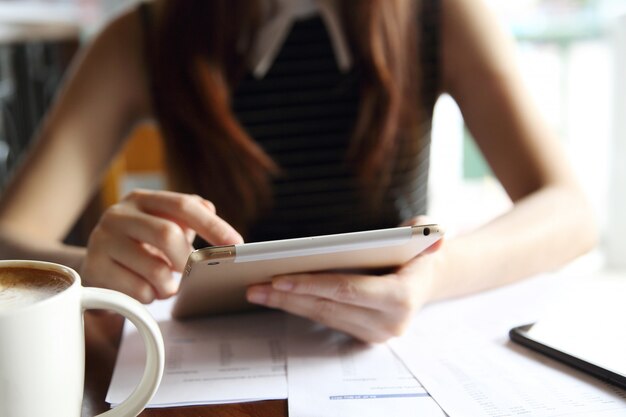 Asian woman drinking coffee with tablet