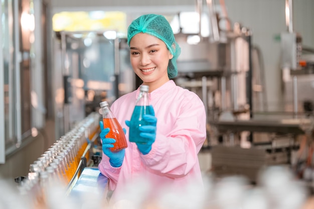 Asian woman employee working Food quality control in Factory and worker inspecting production line beverage tanker in of dairy factory Concept food industry