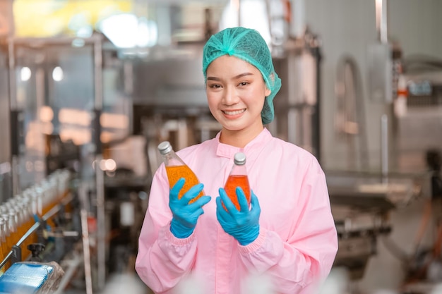 Asian woman employee working Food quality control in Factory and worker inspecting production line beverage tanker in of dairy factory Concept food industry