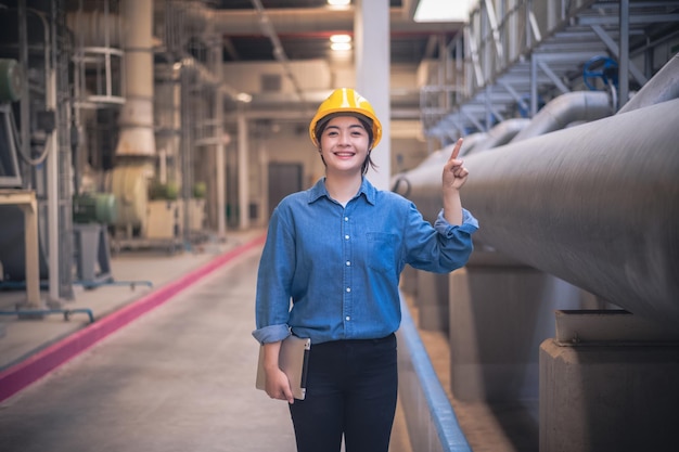 Asian woman engineer standing confident concept Asian woman are engineer factory inspecting machine in factory with computer Asian woman engineer working in factory Asia woman confident