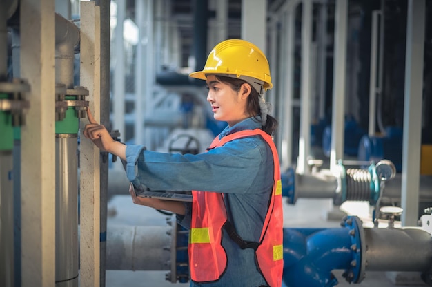 Asian woman Engineer using computer working in factory