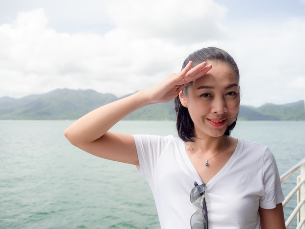 Asian woman on ferry looking at the sea view.