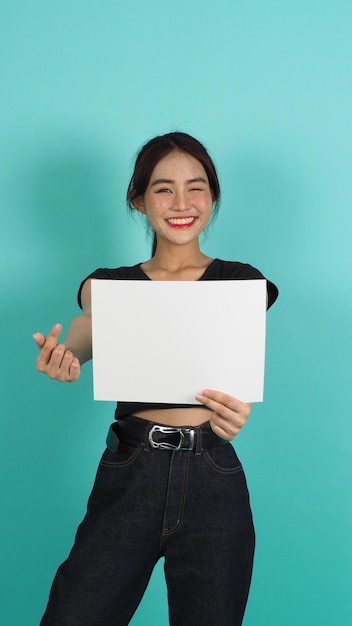 Asian woman hands is holding empty board with Smiling Face on mint green background