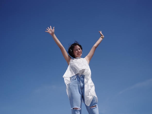 Asian woman happy and smile on the beach and blue sky 