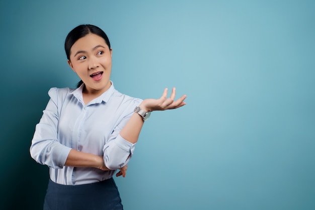 Asian woman happy surprised posing on blue.