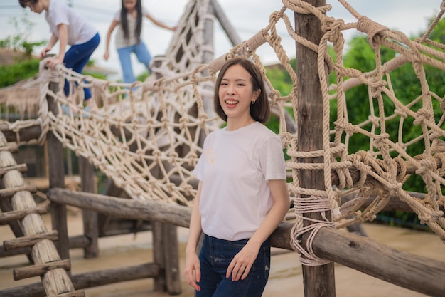 Asian woman happy teacher standing on playground background