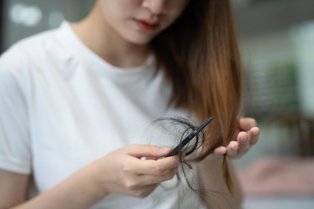 Asian woman have problem with long hair loss attach to comb brush