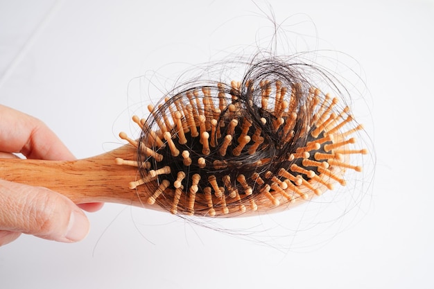 Photo asian woman have problem with long hair loss attach to comb brush