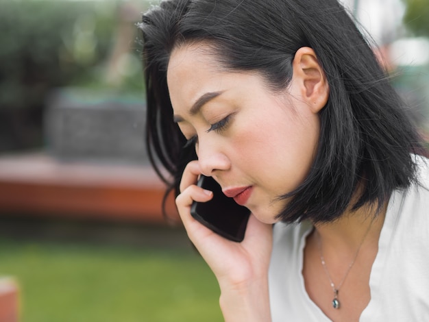 Asian woman have a serious phone conversation. Bad news.