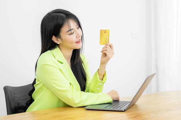 Asian Woman holding bank business credit card with computer laptop Woman hand holding bank credit card Paying using credit card Asian shopaholic shopping online lifestyle