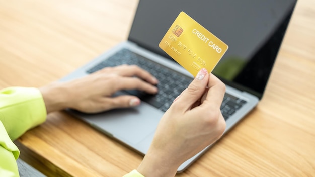 Asian Woman holding bank business credit card with computer laptop Woman hand holding bank credit card Paying using credit card Asian shopaholic shopping online lifestyle