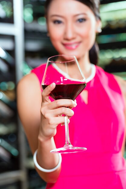 Asian woman holding glass of wine