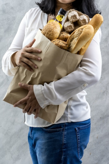 Asian woman holding grocery paper bag