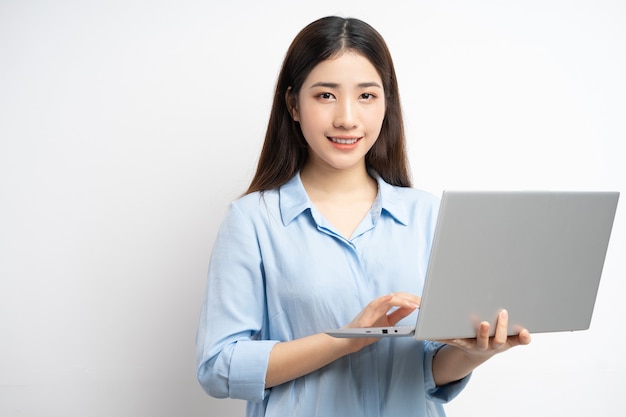 Asian woman holding a laptop in her hand