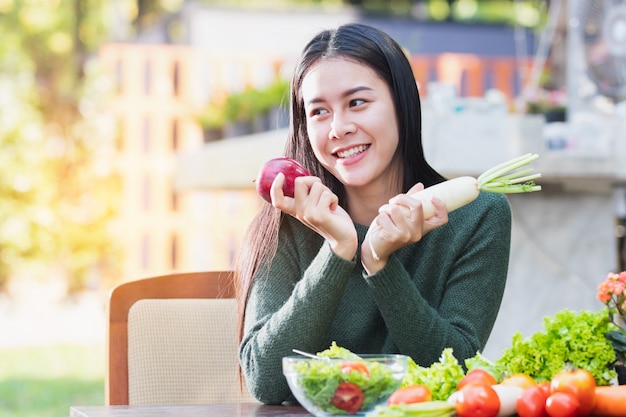 Asian woman holding vegetables and fruit  posing with happy.