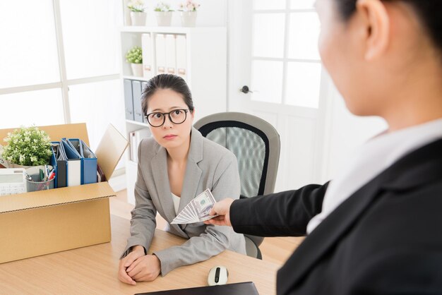 Asian woman is fired and her boss gave her some severance payment. She is unwilling to leave.