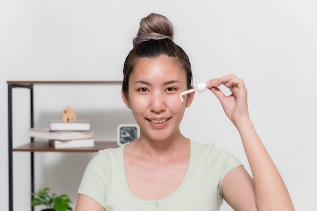 Asian woman is stopping skin serums for her face to make skin soft moisturized white and clear