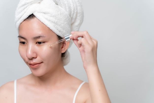 Asian woman is stopping skin serums for her face to make skin soft moisturized white and clear