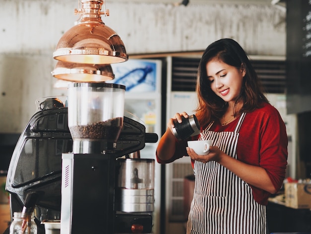 Asian woman making a cup of coffee cup at cafe