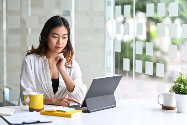 Asian woman office worker working with computer tablet.