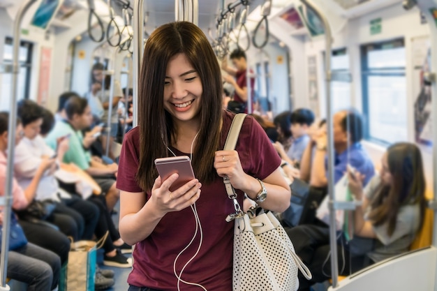 Asian woman passenger with casual suit using the smart mobile phone