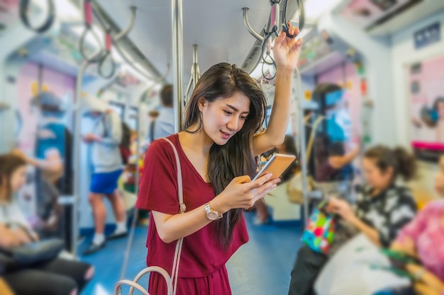 Asian woman passenger with casual suit using the smart mobile phone