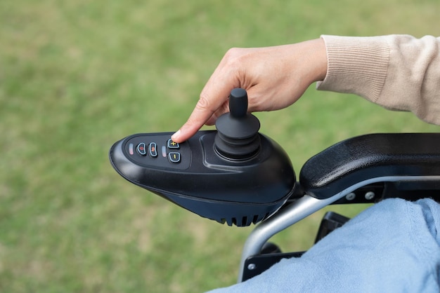 Asian woman patient on electric wheelchair with joystick control at hospital