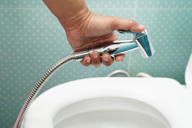 Asian woman patient use toilet support rail in bathroom handrail safety grab bar security in nursing hospital