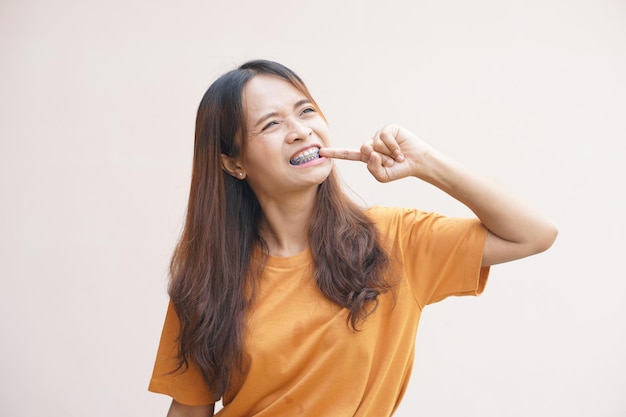 Asian woman picking food scraps from her teeth