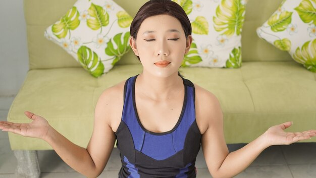 Photo asian woman practicing yoga at home with full concentration