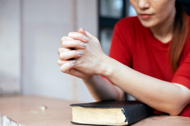 Asian woman praying while holding bible and believe in God