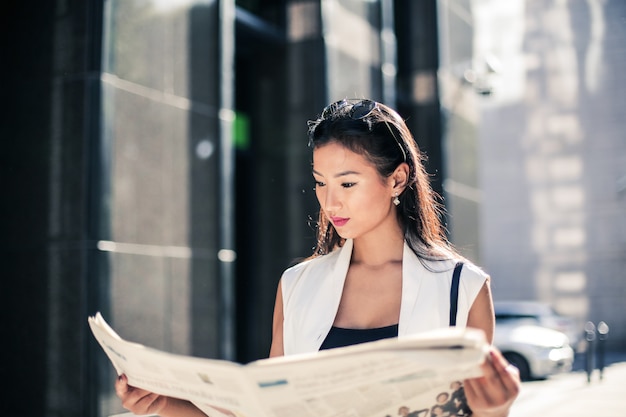 Asian woman reading a newspaper