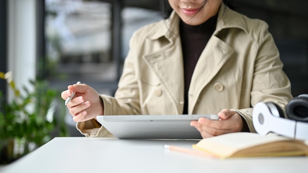 Asian woman remote working at the coffee shop or coworking space using her digital tablet