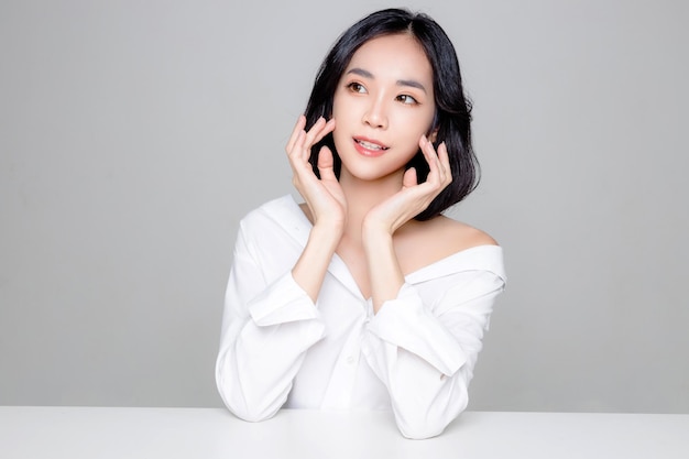 Asian woman short hair with Perfect clean fresh skin Cute female model with natural makeup and sparkling eyes on white isolated background Facial treatment Cosmetology beauty Concept