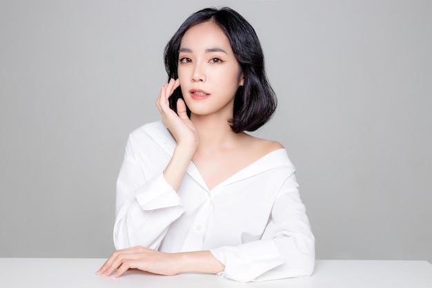 Asian woman short hair with Perfect clean fresh skin Cute female model with natural makeup and sparkling eyes on white isolated background Facial treatment Cosmetology beauty Concept