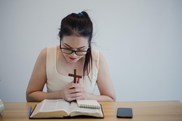 Asian woman sits and makes notes while studying the bible Concept of hope faith christianity religion church online