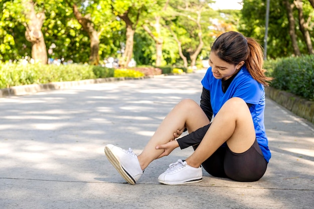 Photo asian woman sitting and feeling pain in her legs