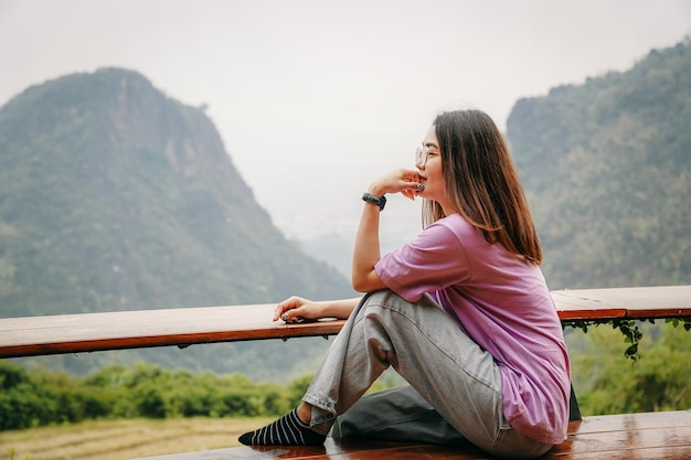 Asian woman sitting and looking out mountains view, people traveling concept.