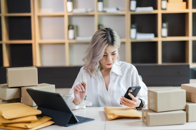 Asian woman sme entrepreneur startup ebusiness owner after checking order from online shopping delivery to customer success shopping small businessxA