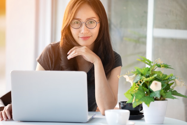 Asian woman in smiling face using laptop.