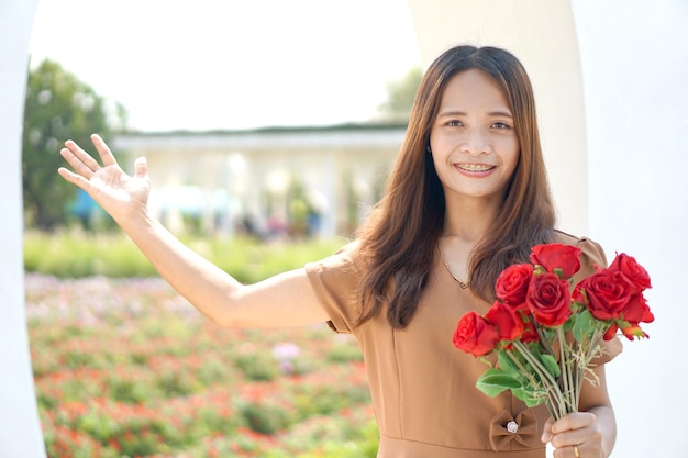 Asian woman smiling happily among beautiful flowers