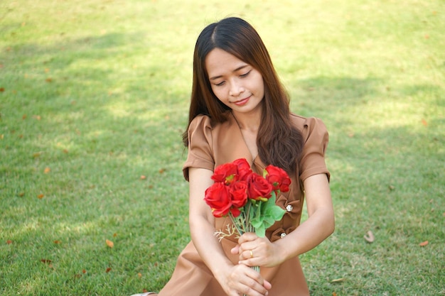 Asian woman smiling happily among beautiful flowers